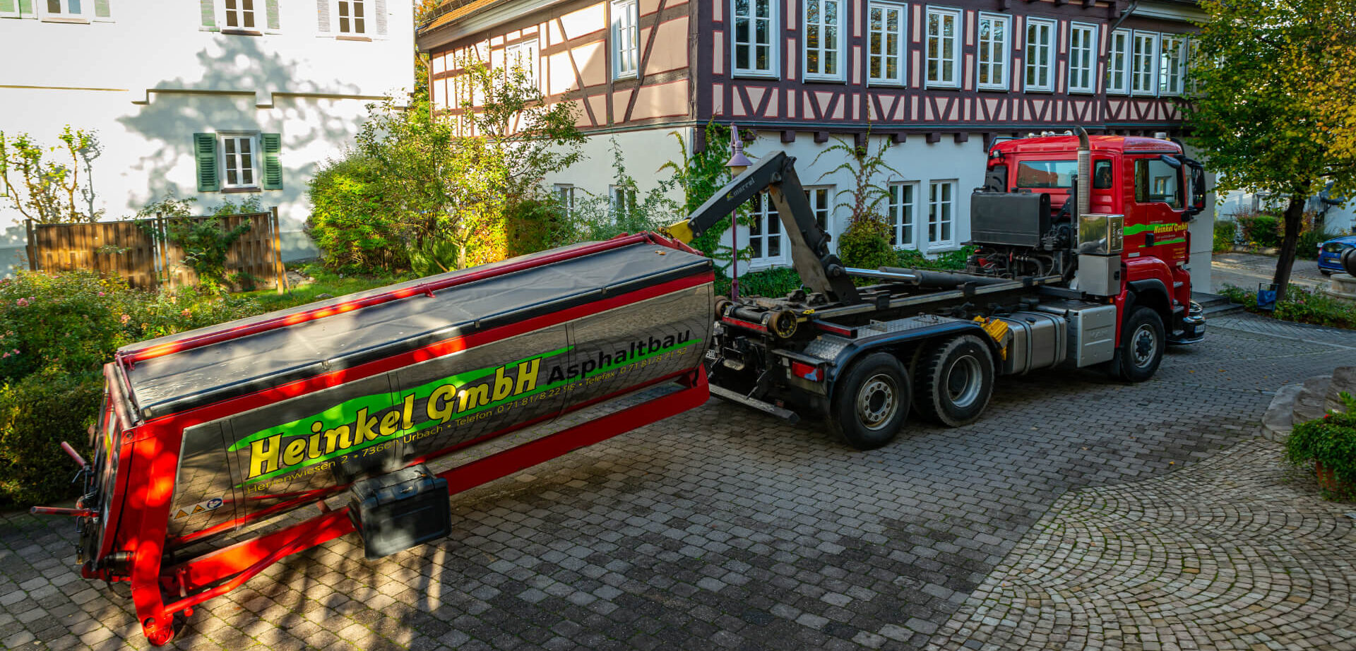 Marrel Abrollkipper. Aufbau auf einem roten Trägerfahrzeug mit Behälter.
