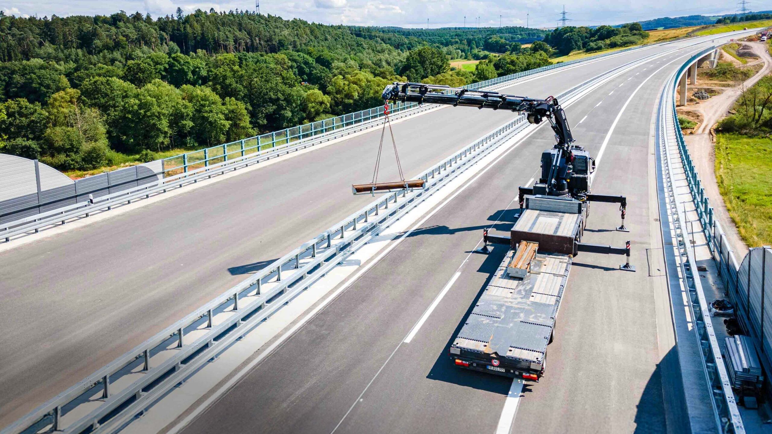 FASSI Ladekran hebt Baustellenelemente auf einer Autobahn